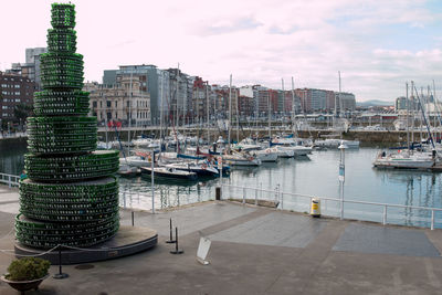 Boats moored in harbor against buildings in city