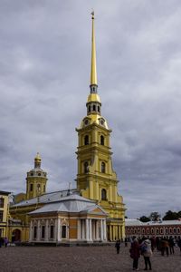 People in front of historic building against sky