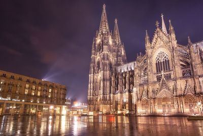 Low angle view of illuminated cologne cathedral against sky at night