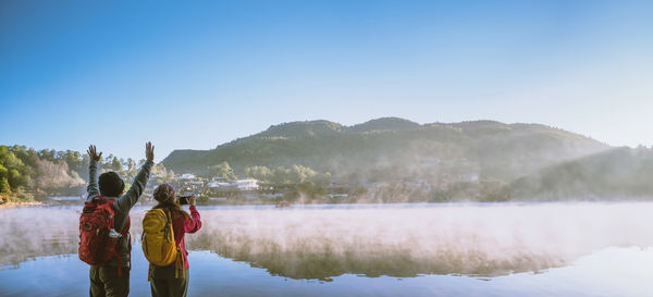 Rear view of woman standing in lake