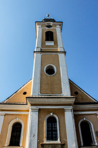 Low angle view of church tower against blue sky