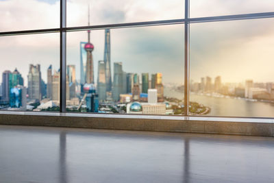 Buildings against sky seen through window