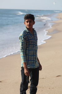 Portrait of young man standing on beach