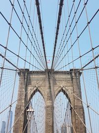 Low angle view of suspension bridge against sky in city