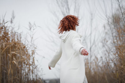 Pretty young woman in trendy white clothes poses in motion