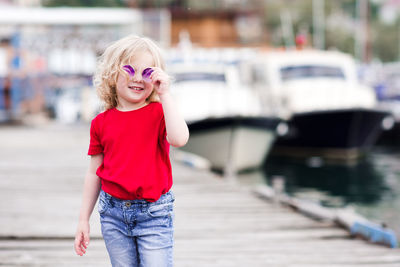 Smiling girl wearing sunglasses on jetty