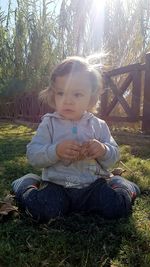 Cute boy sitting on field