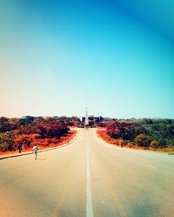 People walking down road towards monument