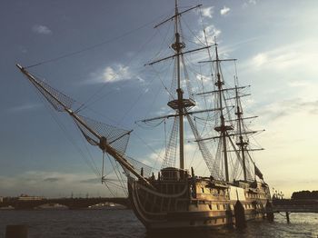 Sailboat moored at harbor against sky