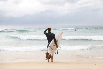 Full length of boy on beach against sky