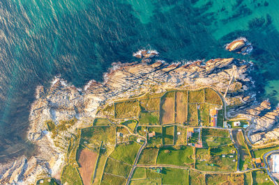 Land plots on the shore on rock, marked by stone fences, top view.