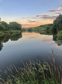 Scenic view of lake against sky at sunset