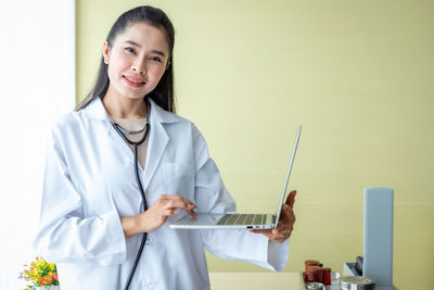 Portrait of a smiling young woman using mobile phone