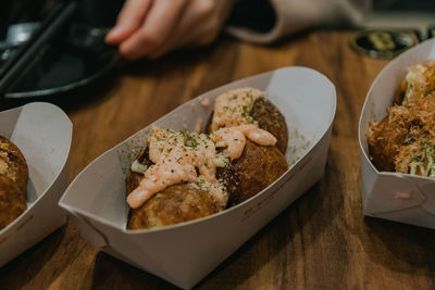 Takoyaki in paper boats on table.