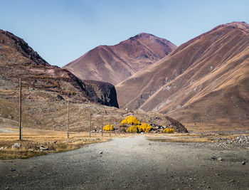 Road by mountains against clear sky