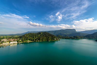 Scenic view of lake by mountains against blue sky