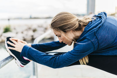 Young woman stretching and warming up for training at the beach