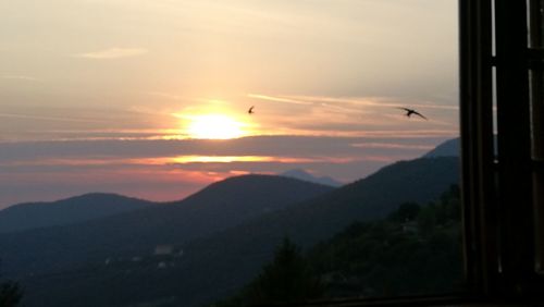 Scenic view of silhouette mountains against sky at sunset