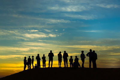 Group of people watching sunset in the arab desert