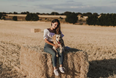 Mid adult woman with dog on agricultural field