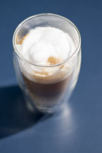 High angle view of coffee with froth in glass on table