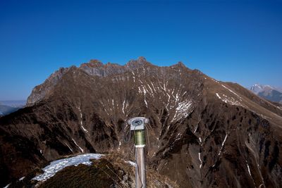 Scenic view of mountains against clear blue sky