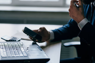 Midsection of man using mobile phone