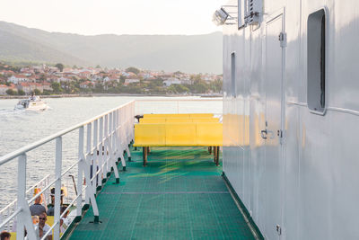 Empty yellow seats in boat on sea during sunset