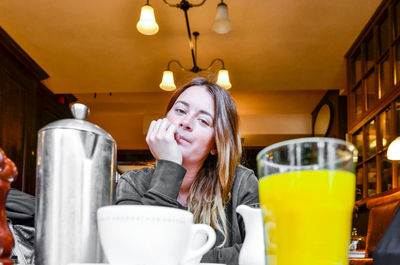 Portrait of smiling woman sitting by table