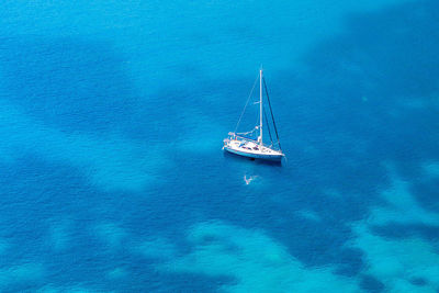 High angle view of sailboat on sea against blue sky