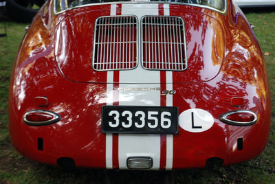 Close-up of red vintage car on field