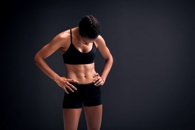 Woman standing against black background