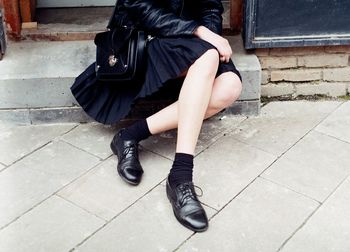 Low section of woman sitting on doorway