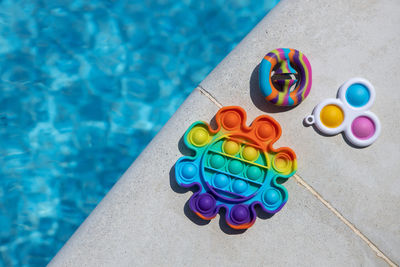 Anti-stress toys pop it, simple dimple, snapperz on side of pool, copy space. 