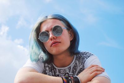 Portrait of young woman wearing sunglasses against sky