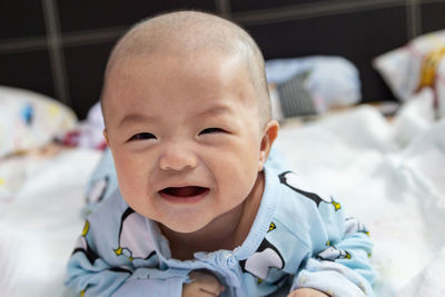 Portrait of cute baby lying on bed