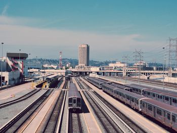 Trains on railroad track with city in background