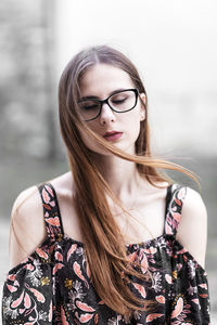 Young brown-haired millennial with glasses and light dress