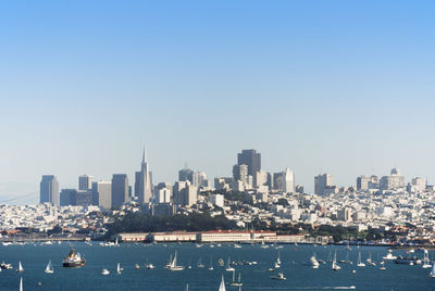 Scenic view of sea by buildings against clear sky