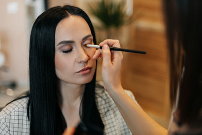 Close-up of a makeup artist doing eye makeup