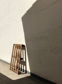 Empty pallet against wall on sunny day