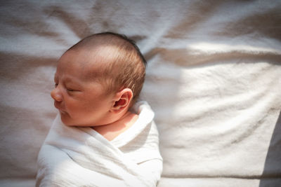 Close-up of baby boy sleeping on bed at home