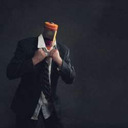 Midsection of person holding umbrella against black background