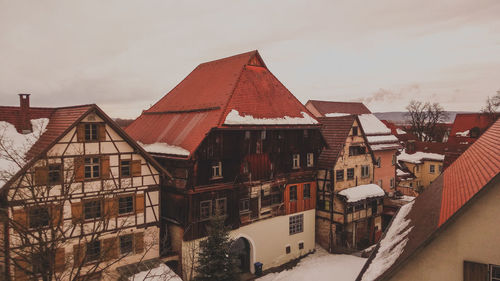 Houses in town against sky during winter