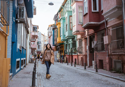 Rear view of people walking on street in city