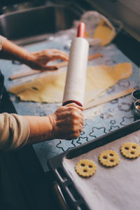 High angle view of woman preparing dough with rolling pin