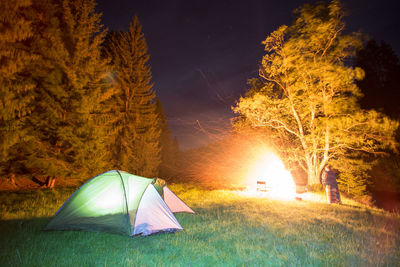 Tent on landscape against sky at night