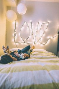 Woman with dog lying on bed at home