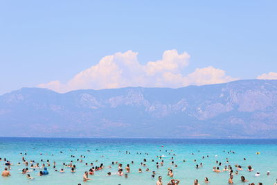 Group of people on beach against sky