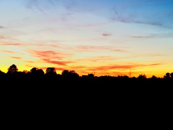 Silhouette landscape against sky at sunset